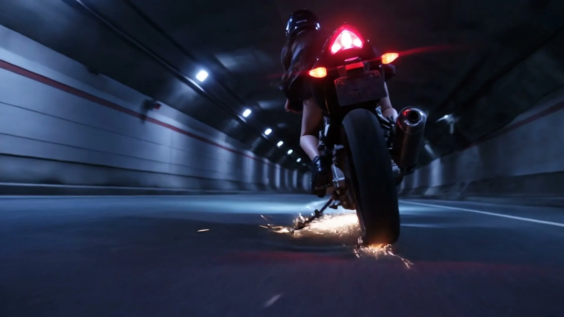 Motocykl w tunelu z iskrami spod koła — kadr z teledysku AI „To Ty”